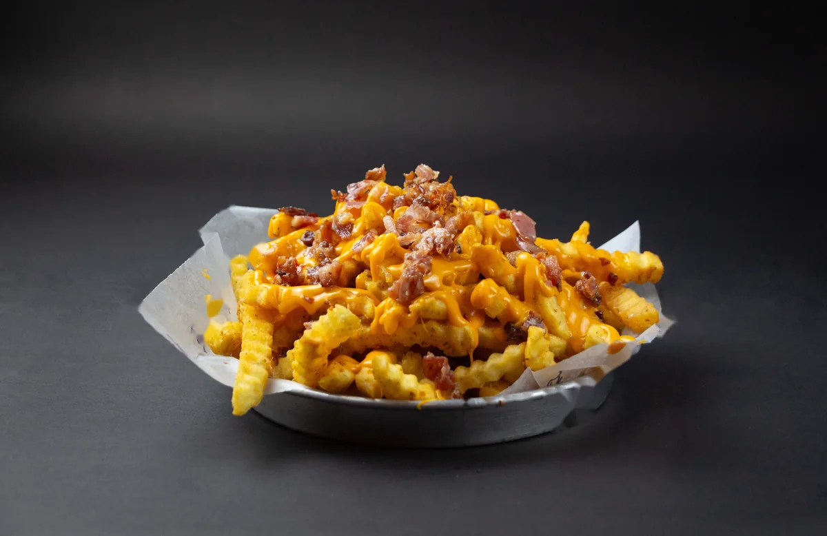 Papas fritas con salsa cheddar y panceta: una guarnición que se costea con sub-recetas